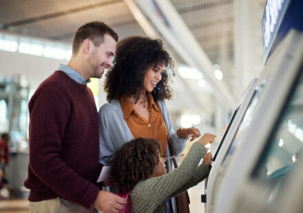 A family of three using a touchscreen