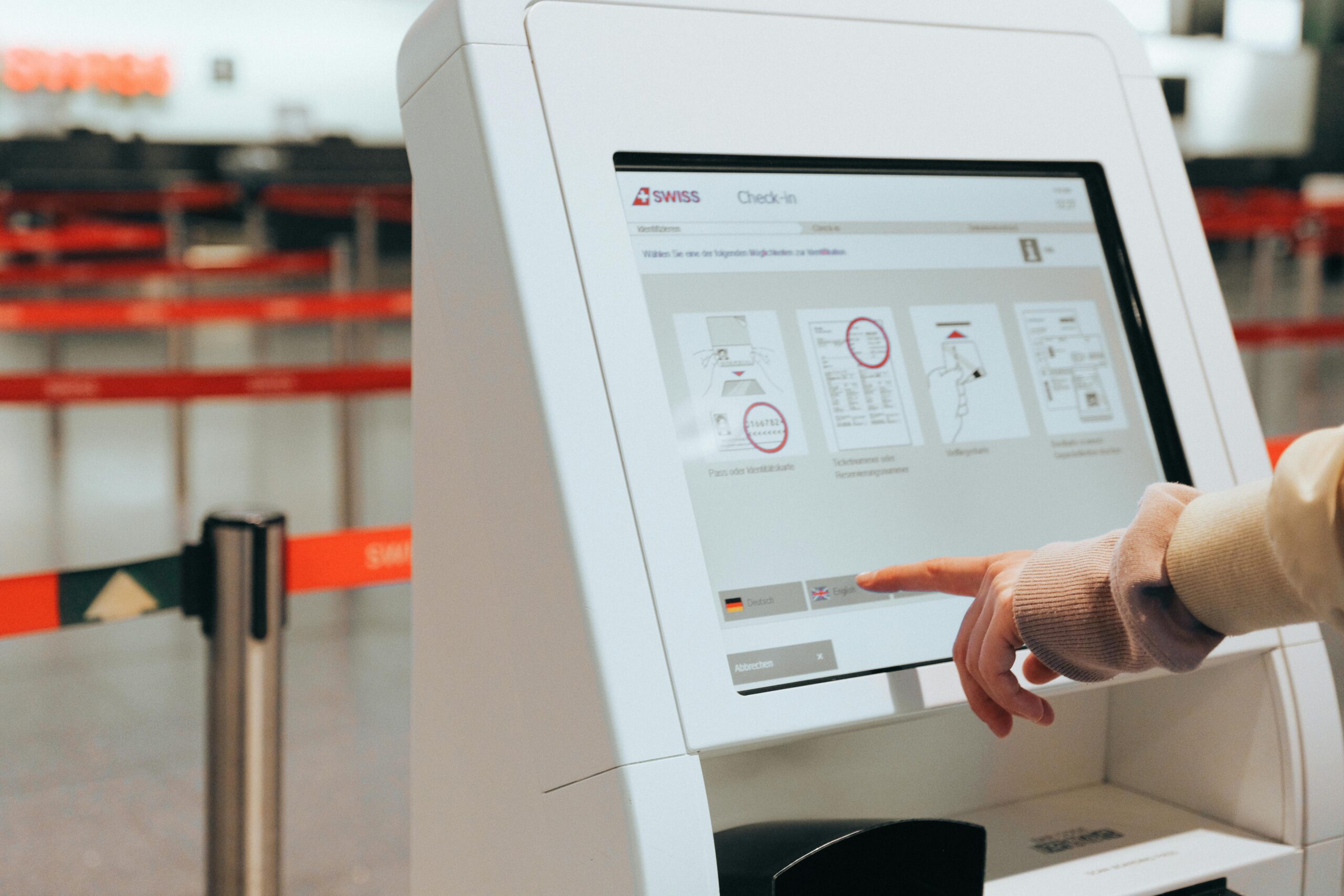 A person checking in at the airport using a self service touchscreen