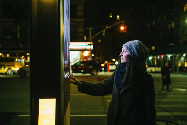 A lady using an outdoor touchscreen kiosk