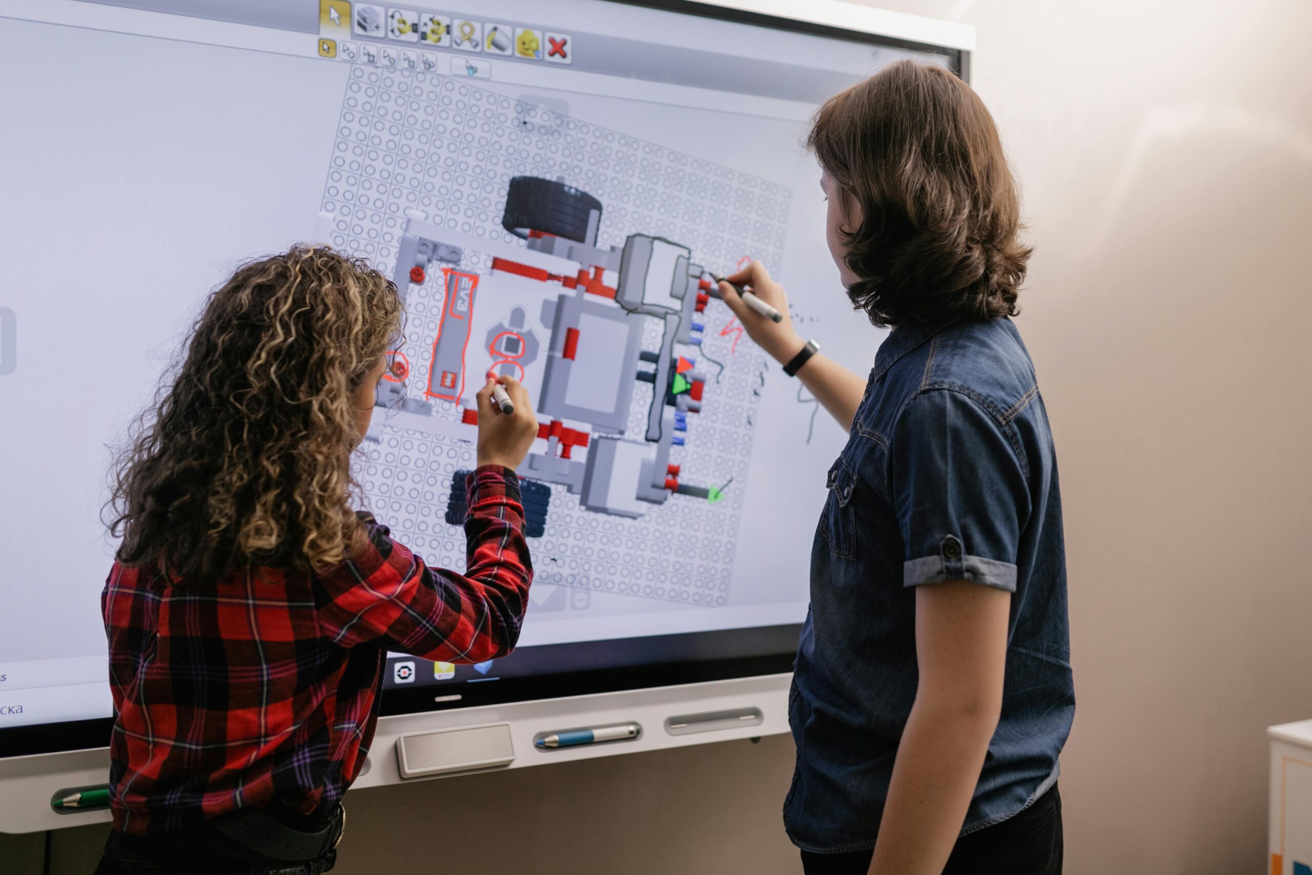 Two teenagers using a touchscreen