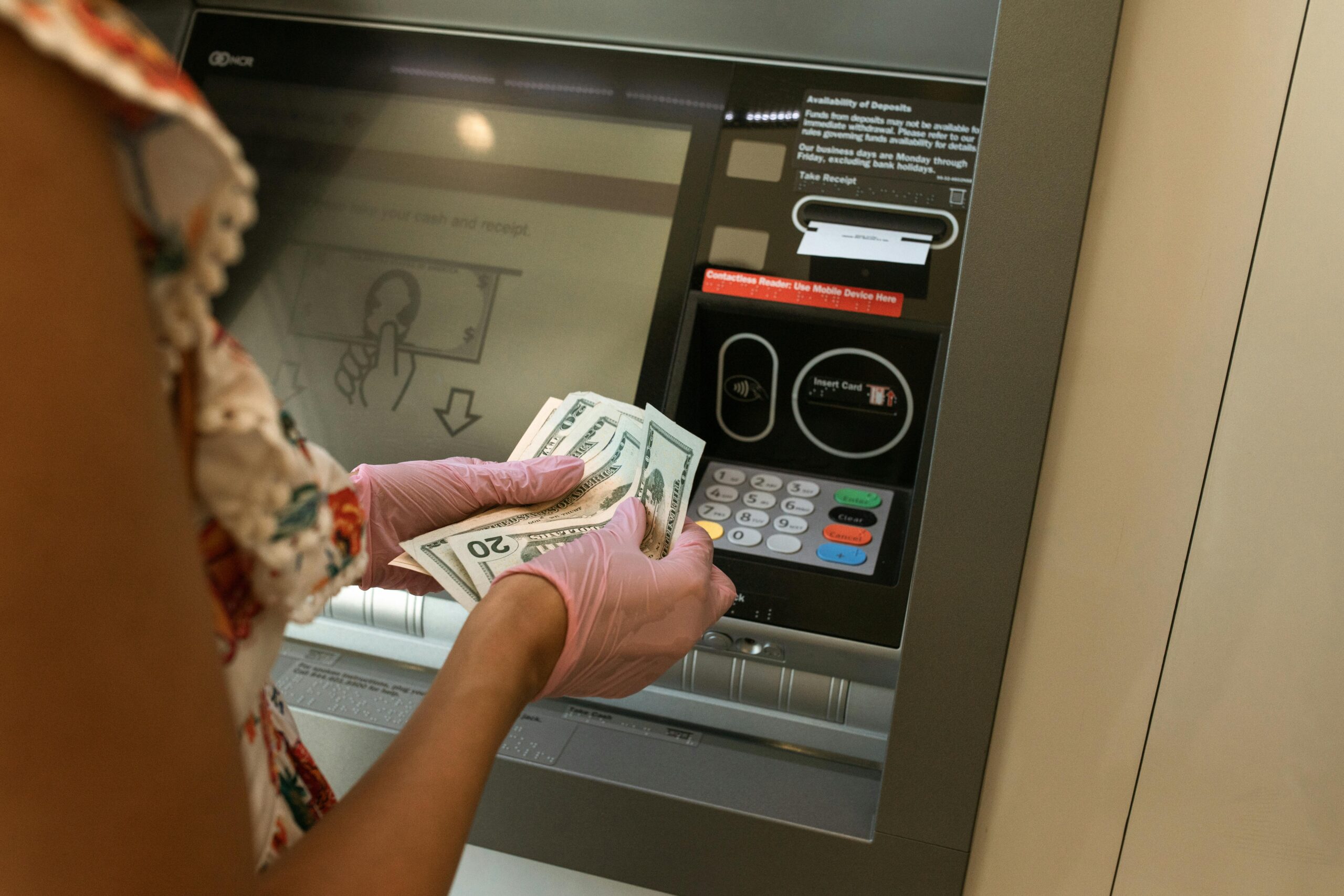 A person taking money out of an ATM